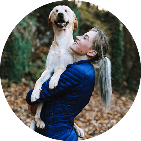 A pretty woman is holding her pet dog